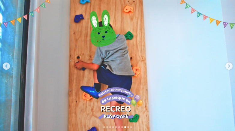 Niño escalando el muro de escalada interior del centro