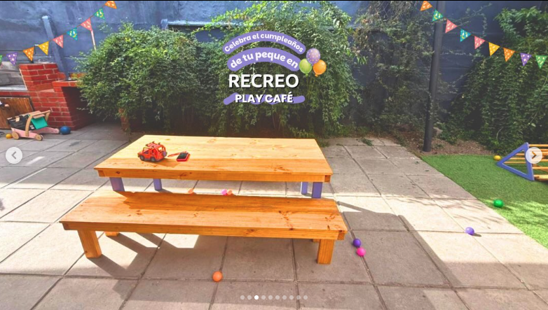Mesa y banca de madera en el patio, decoradas con guirnaldas de colores