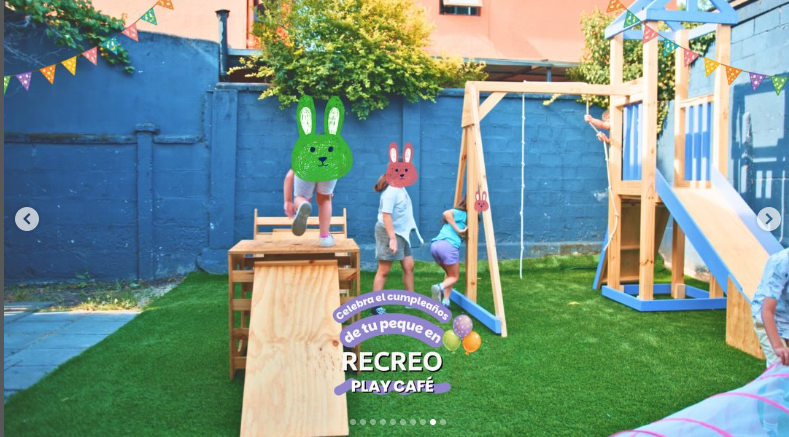 Niños jugando en el patio con juegos de madera y columpio